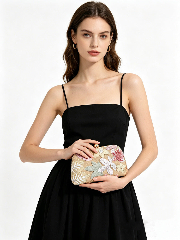 Modella con pochette floreale rosa e oro e abito nero