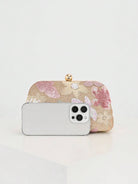 Pochette rosa e oro a confronto con uno smartphone per la misura