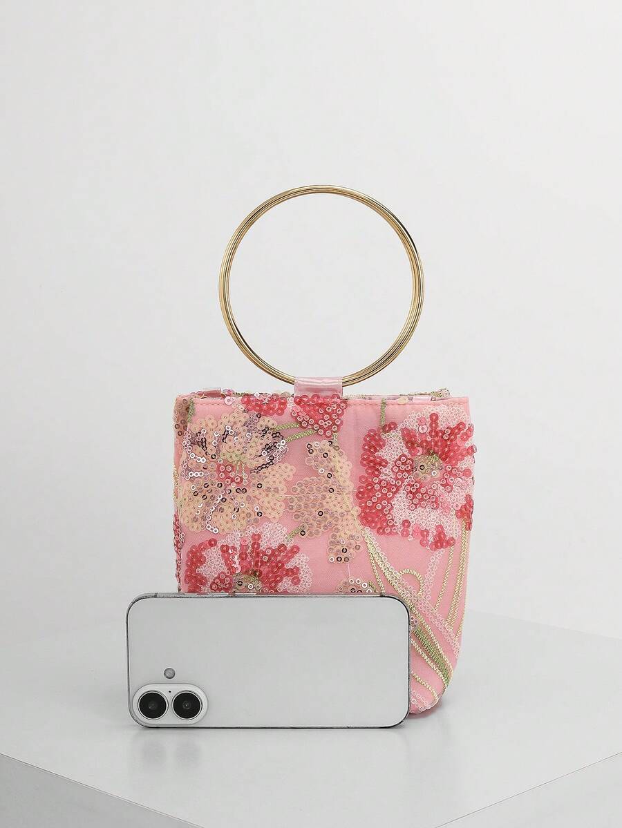 Mini borsa rosa a confronto con uno smartphone per la misura