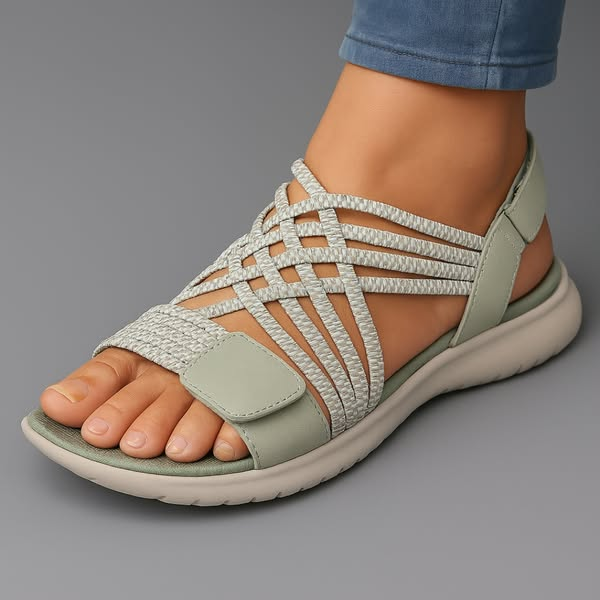 Sandali comfort da donna in beige con fasce elastiche intrecciate, indossati con jeans