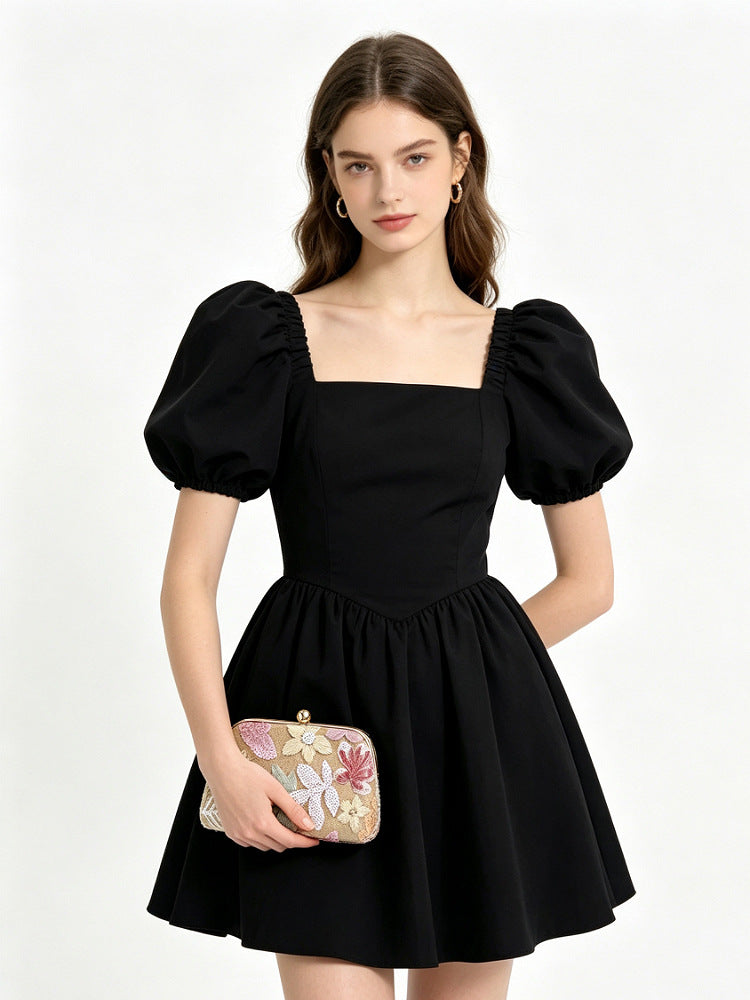 Pochette floreale rosa e oro abbinata a un abito nero