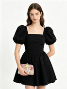 Pochette floreale rosa e oro abbinata a un abito nero